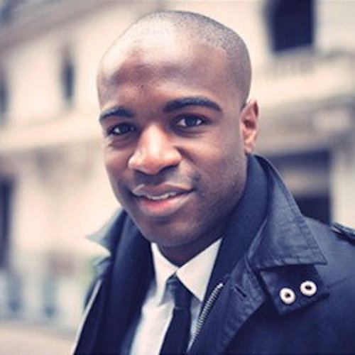 Mike Thompson, a young black man, professionally dressed, as always, smiling at the camera after a long Alumni board meeting.